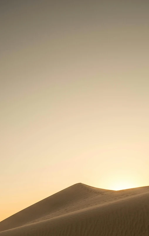 the sun is setting over the sand dunes