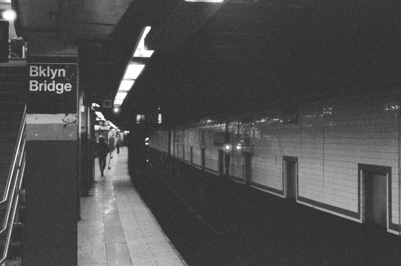 people are walking on a platform in an empty station