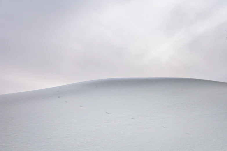 a small kite flying over a snowy field