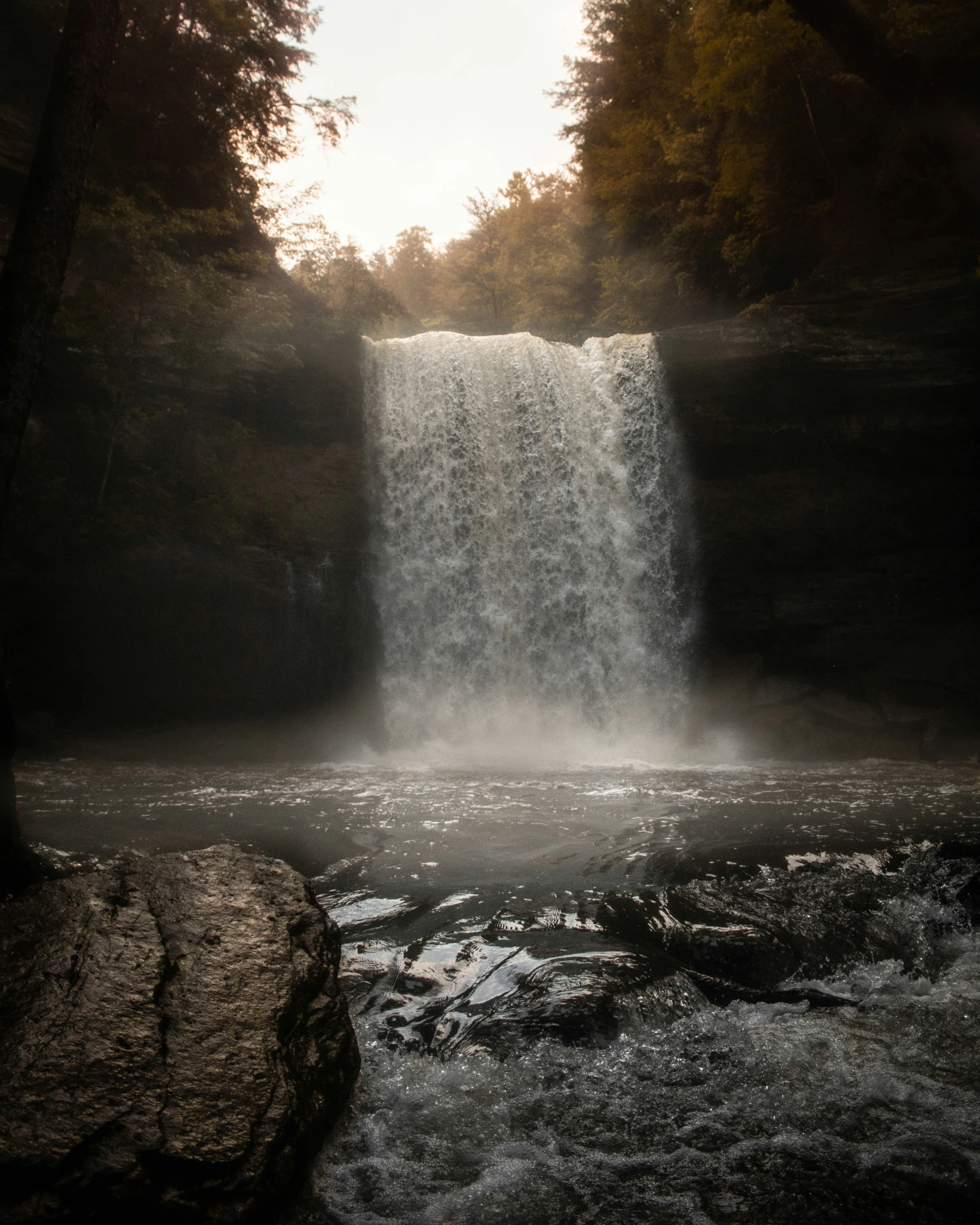 sun beams shining from a small waterfall