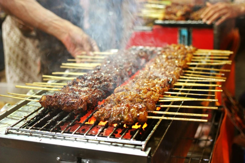 some bbq meat is being grille on skewers