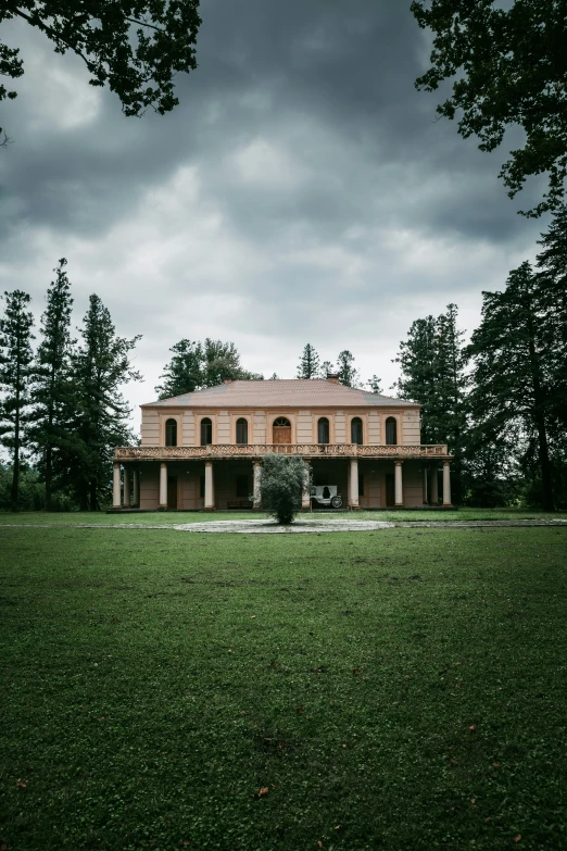 an old house in a field next to some trees