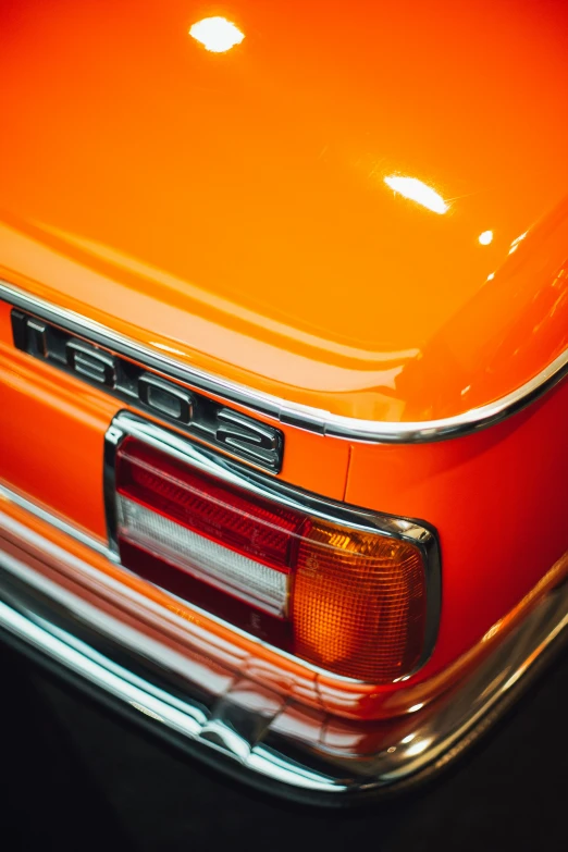 a bright orange car is parked in a parking lot