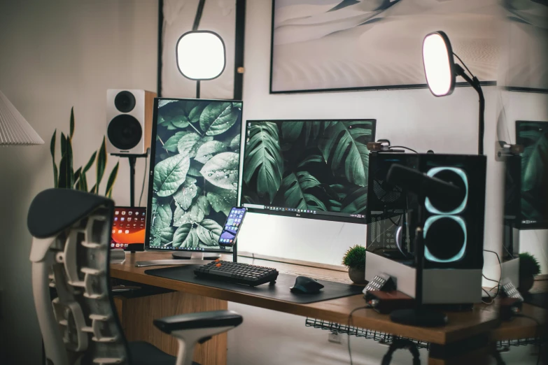 a home office with three computer monitors on top of a desk