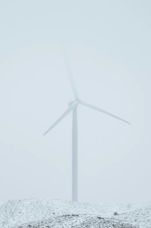 wind turbine in snow covered ground with tree