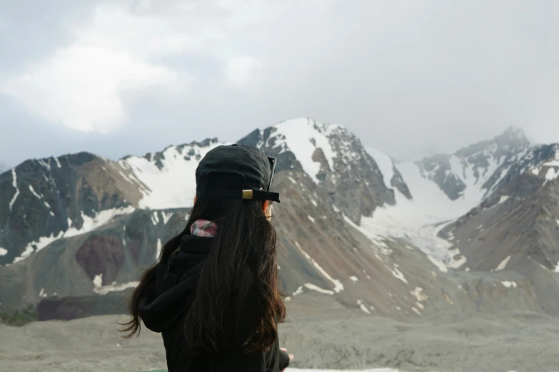 long dark haired person with a ski hat covering their face