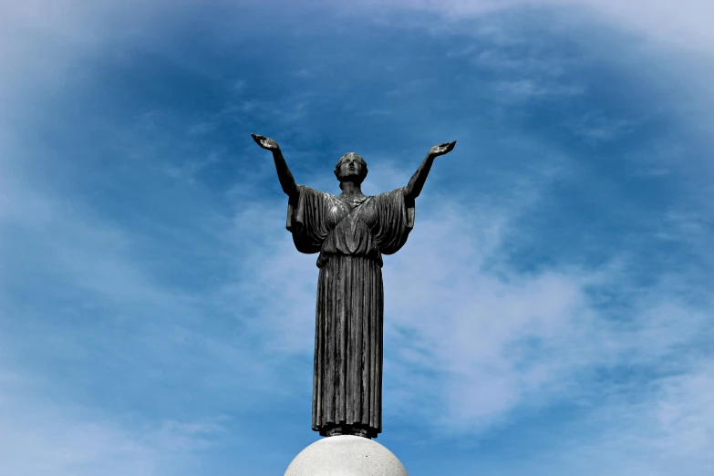 a statue with a woman standing on top of it