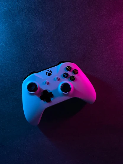 a white controller on a blue and purple background