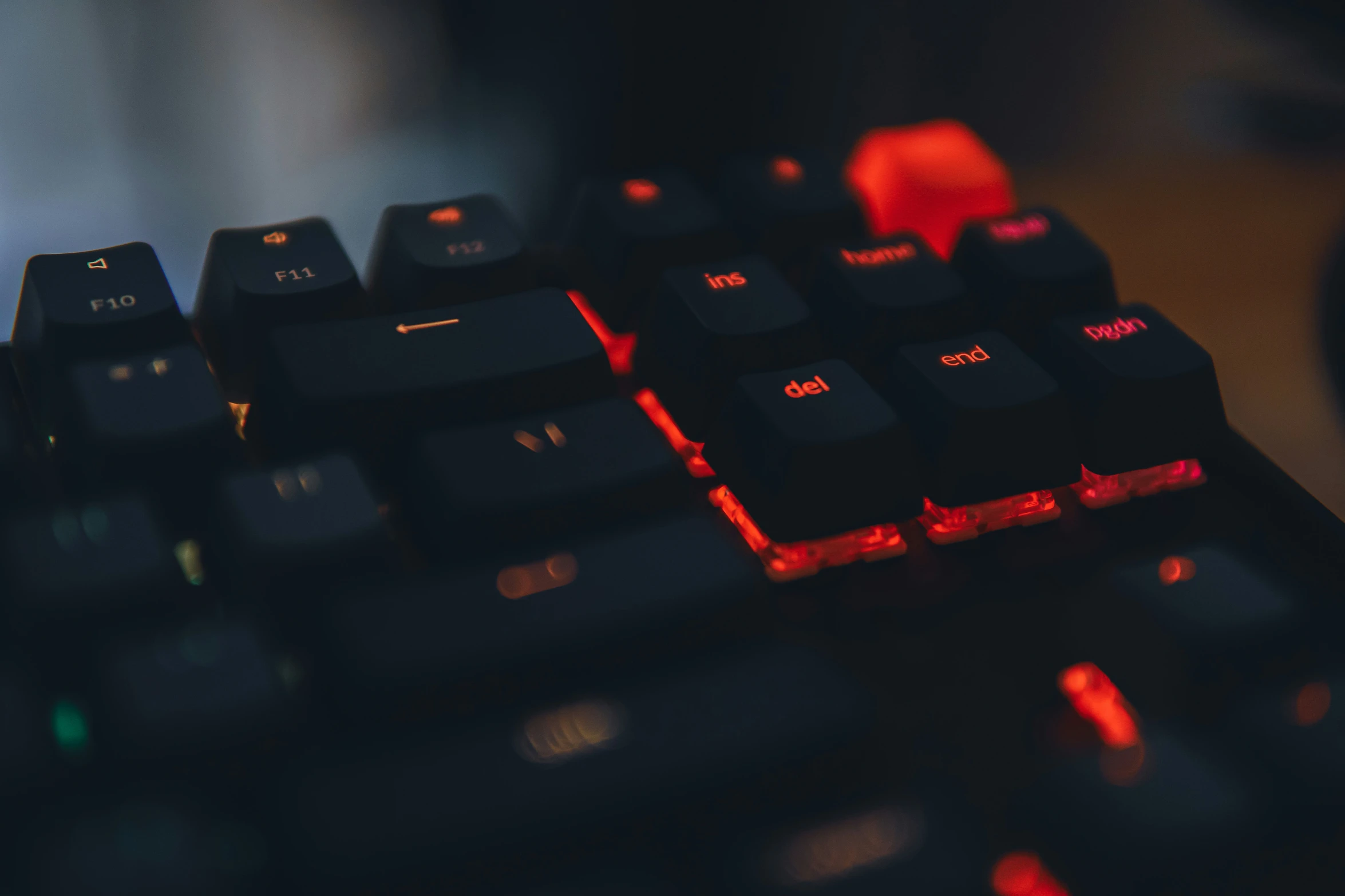 a close up of a computer keyboard with red lights