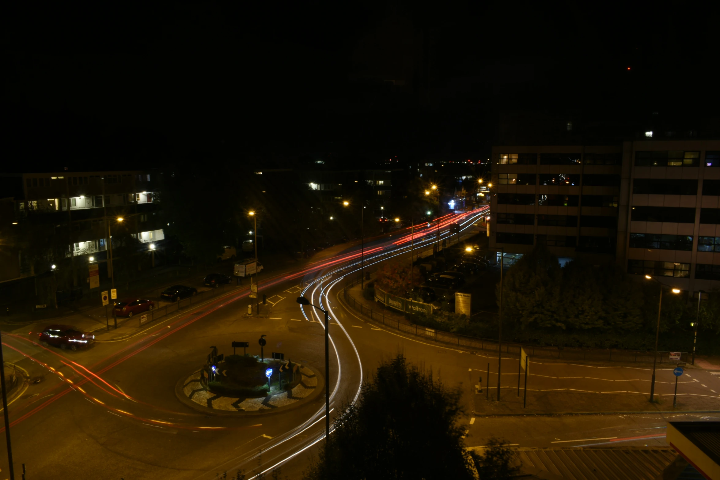 traffic light trails down the road near a city street