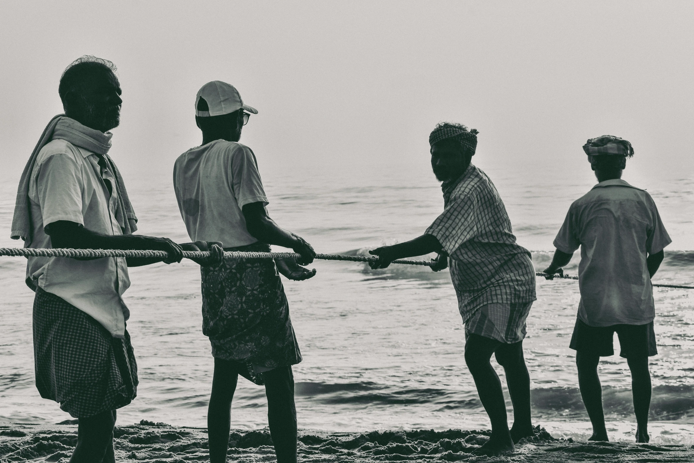 four people with a rope on the beach