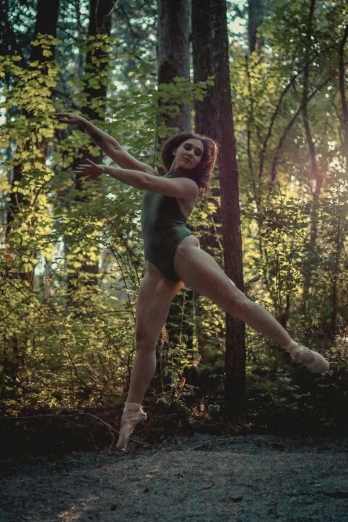 a person dancing in the woods near trees
