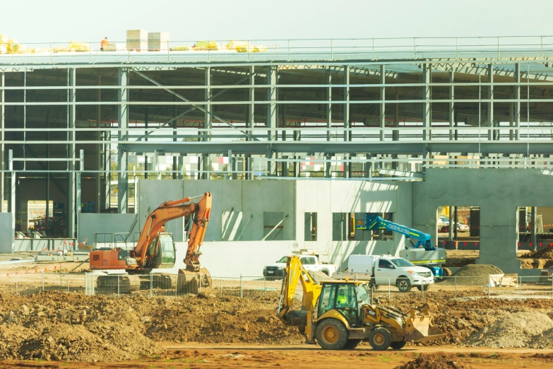 a building under construction with an excavator and machinery