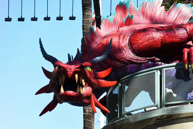 a red dragon sculpture hanging from a balcony