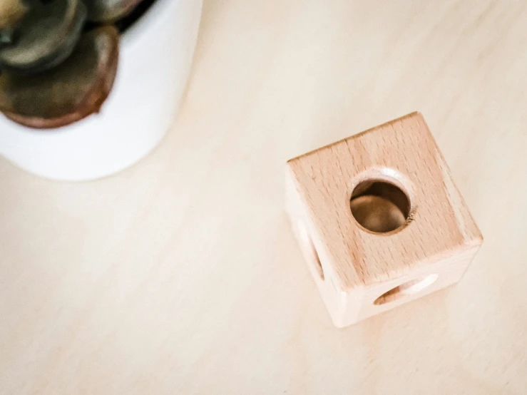 an empty, wooden container next to a small piece of wood