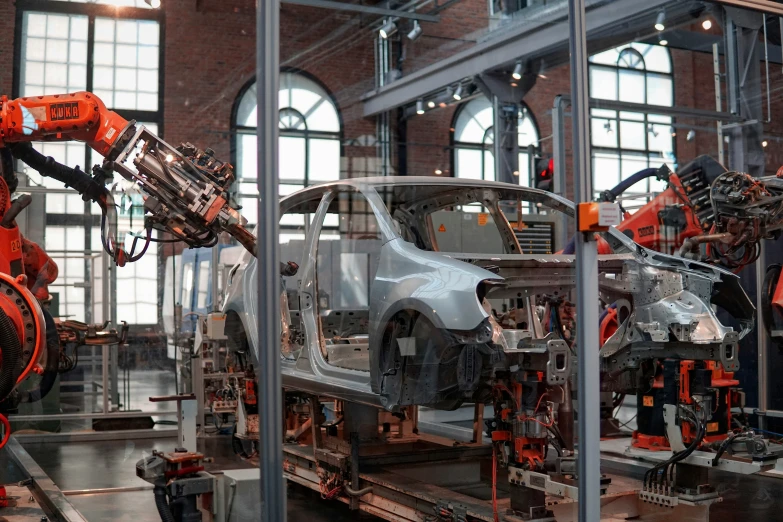 robots working on cars in an assembly building