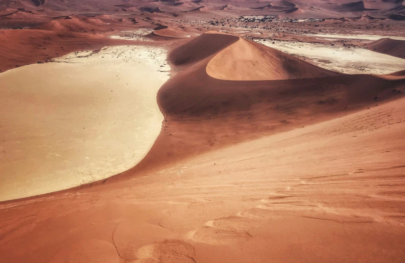 sand dunes surrounded by hills and sand water