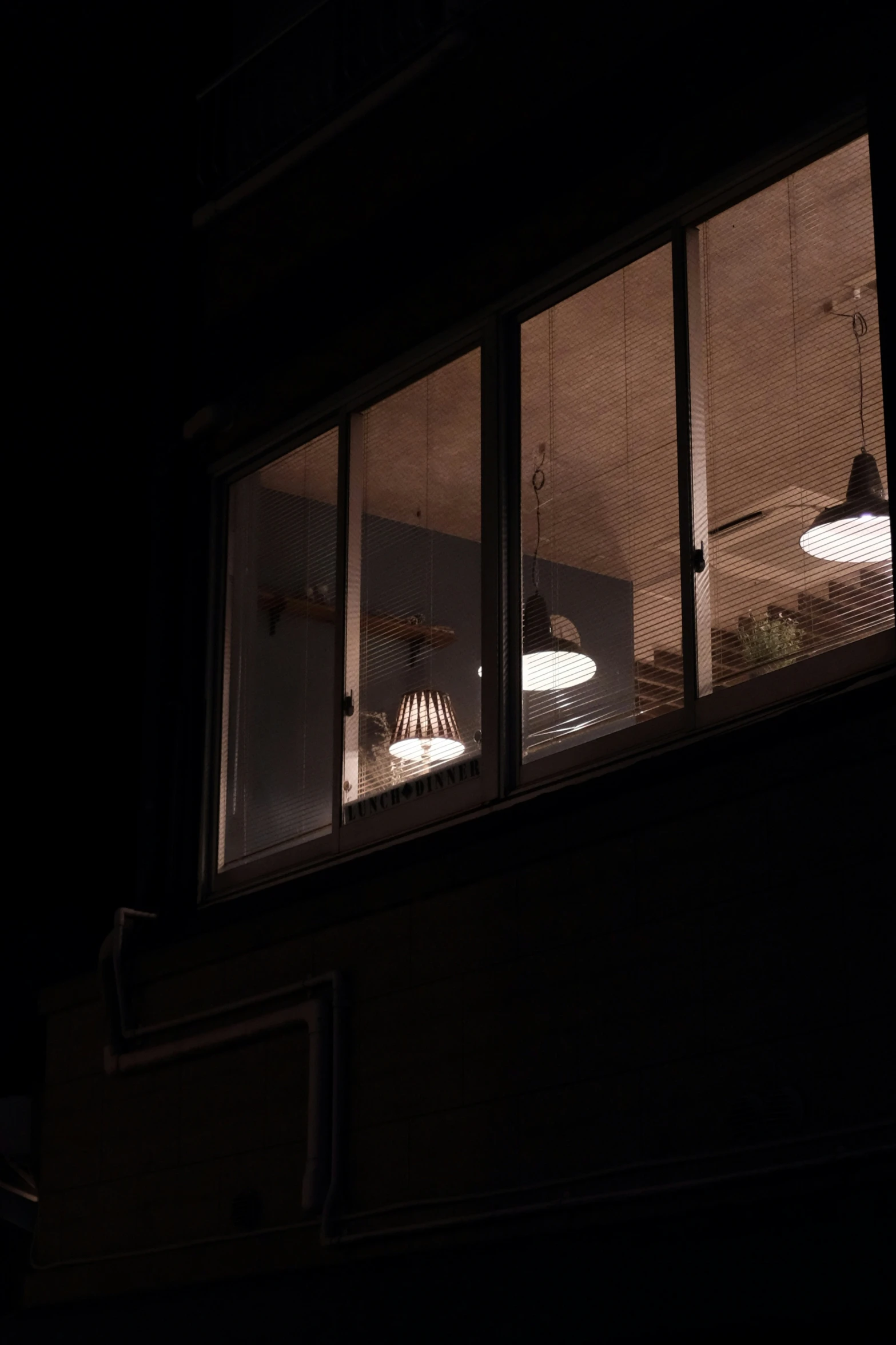 a dark house with several lights hanging in the window