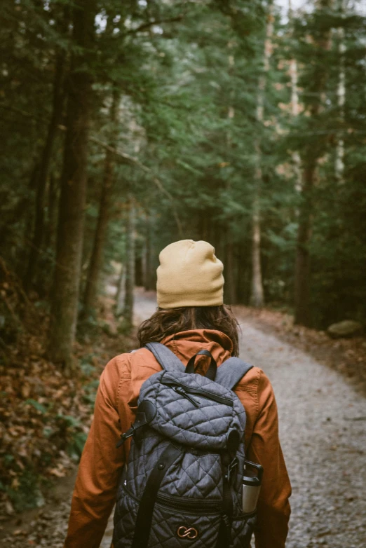 a person walking down a dirt path with a backpack