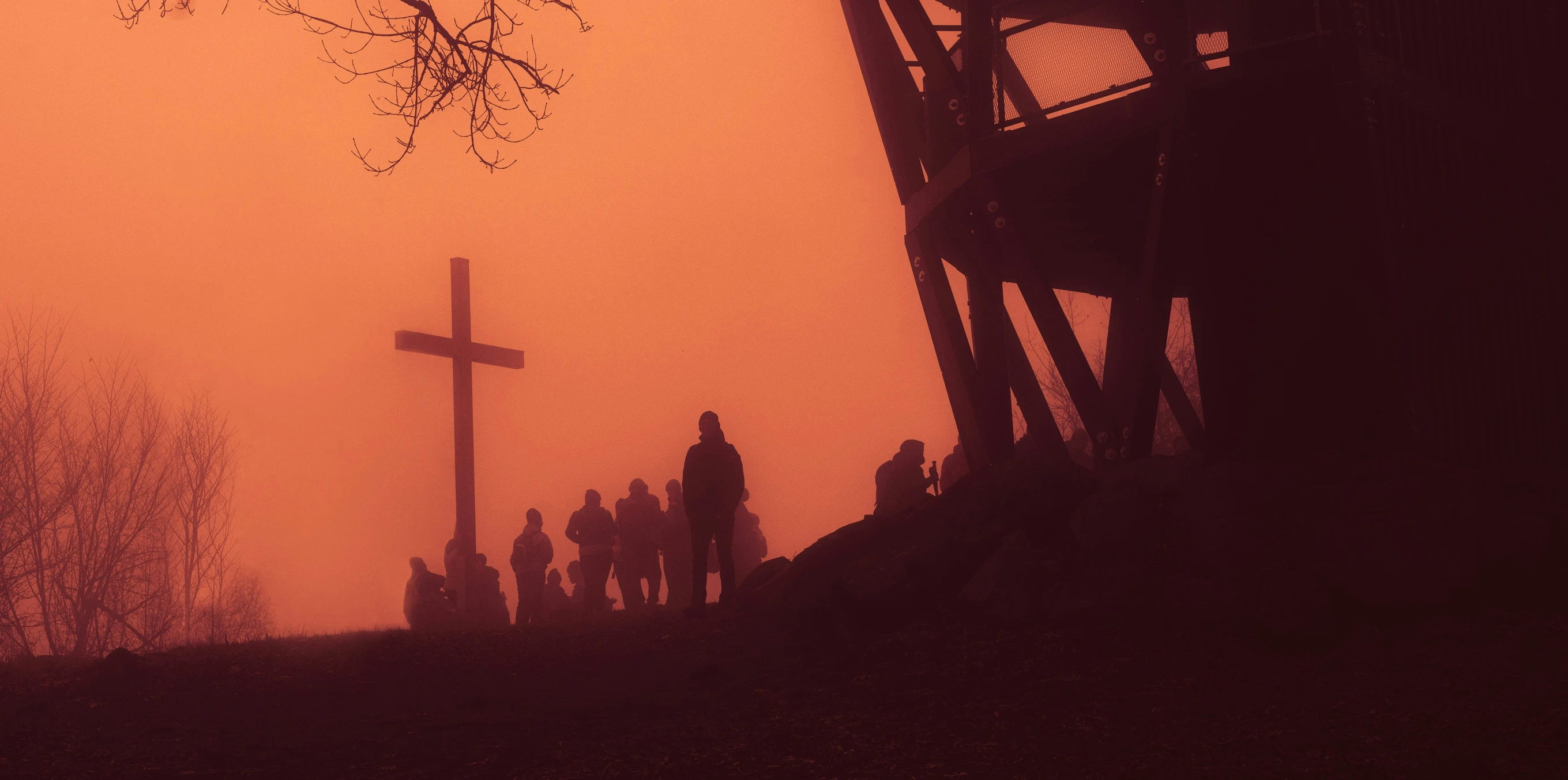 people walking toward a cross in a foggy area