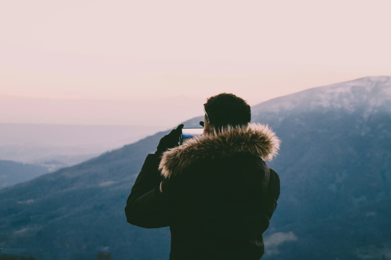 a man takes a po while standing at the top of a mountain