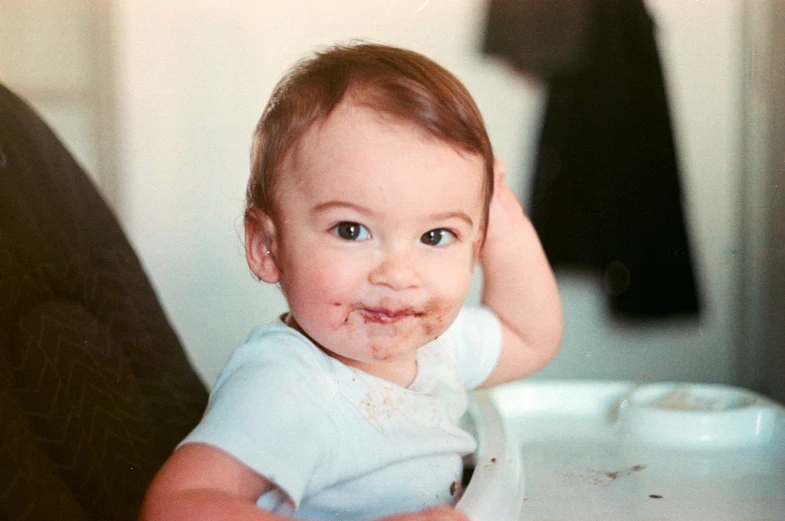 a young child is holding on to his hands and making a mess in front of his face