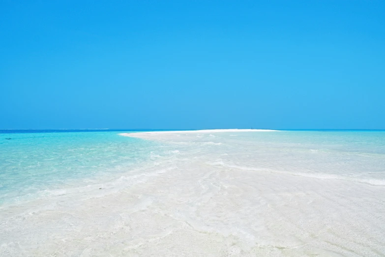 white sand covered in blue water under a clear sky