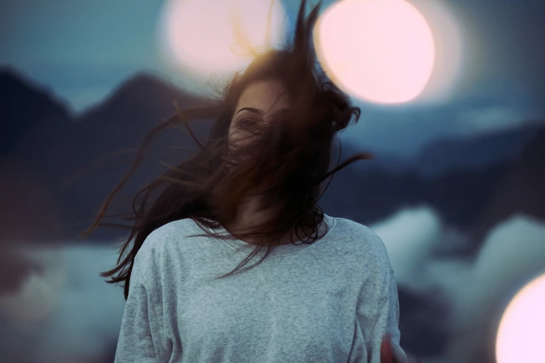 a woman looking up at the sun through her hair