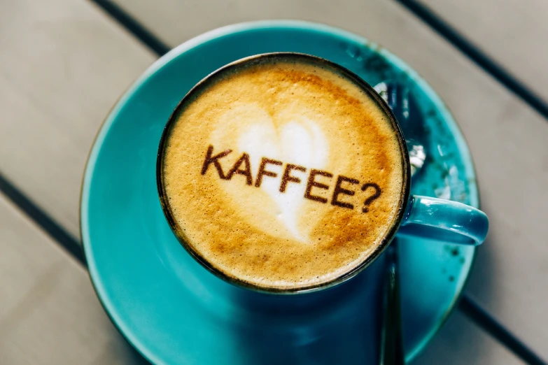 a cup filled with latte that says kaffe