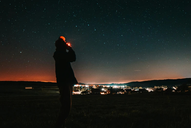 a woman is looking at the sky while holding a cellphone