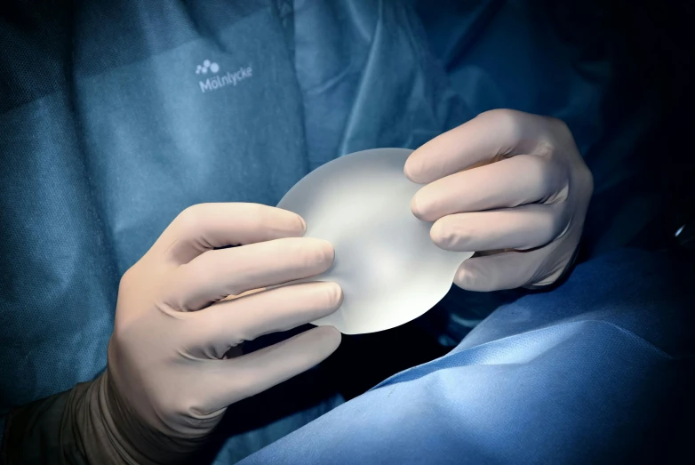 a person wearing a white glove holds a bowl