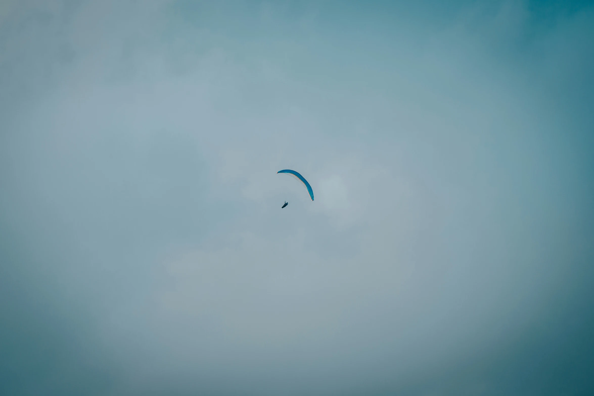 two large parachutes flying through the cloudy sky