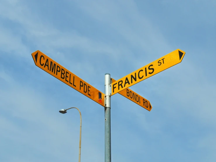 a street sign on top of a pole with a lamp post