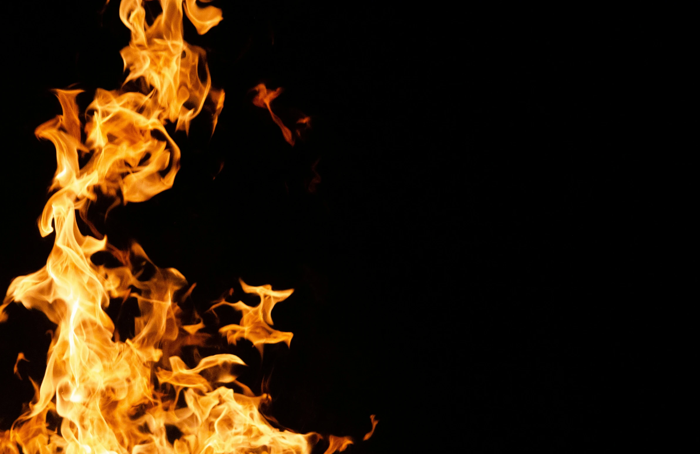 a bonfire burning in the dark with a black background