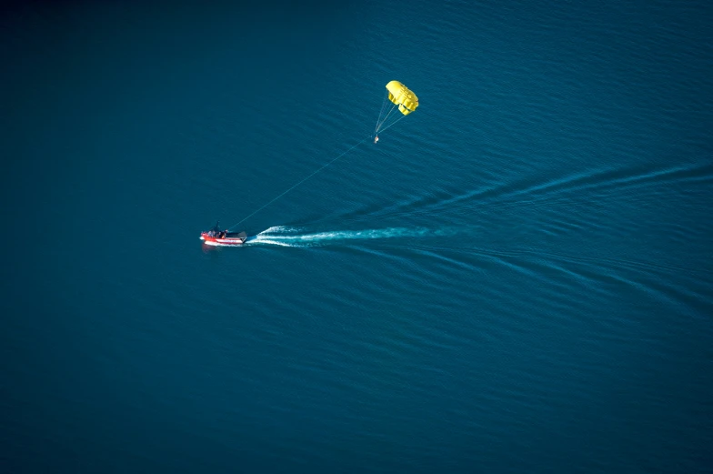 two people on surfboards with kites flying above the ocean