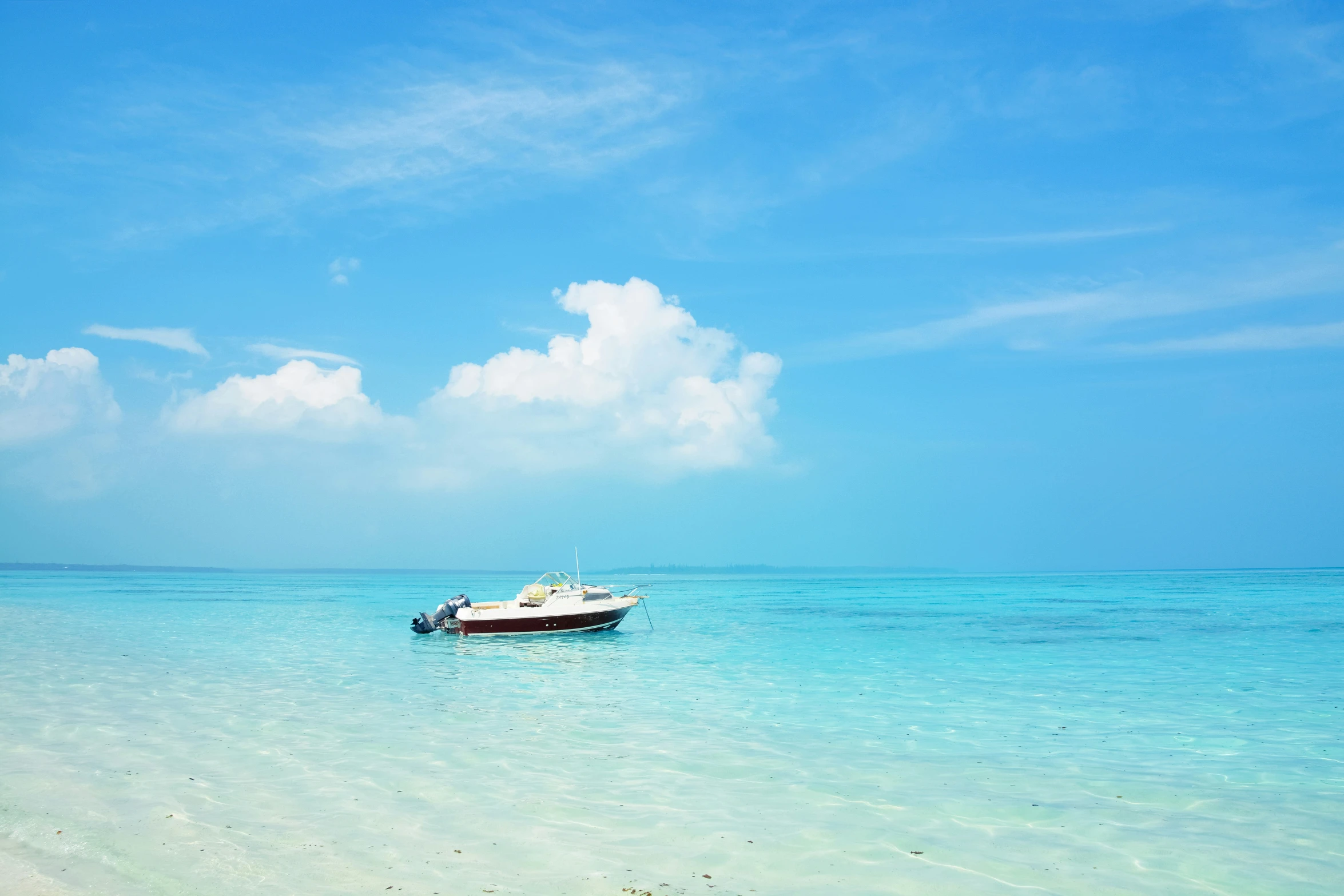 boat on calm ocean waters, under bright blue skies