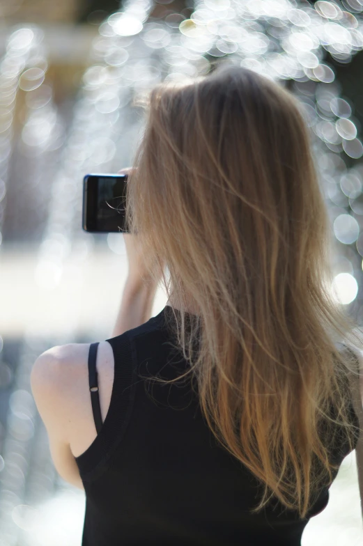 a woman holding a camera up to her side