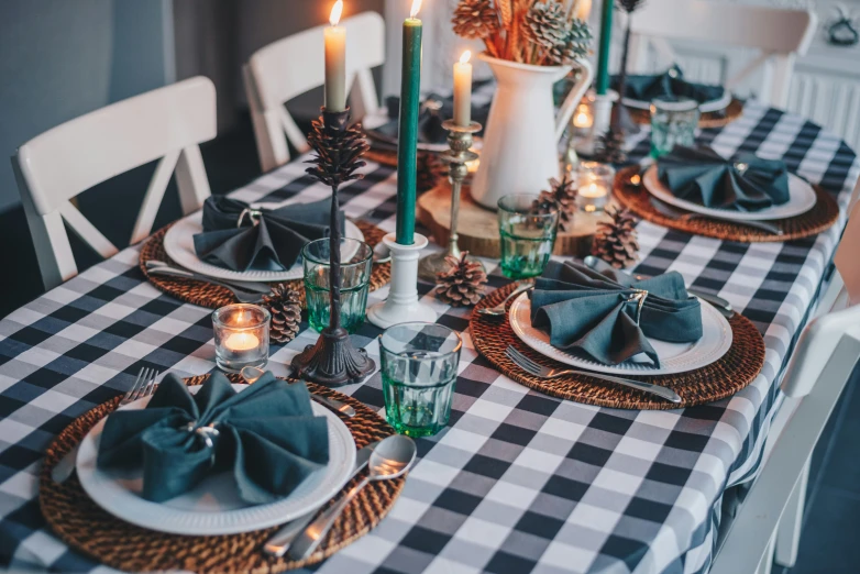 a christmas table setting with black and white checkered tablecloth