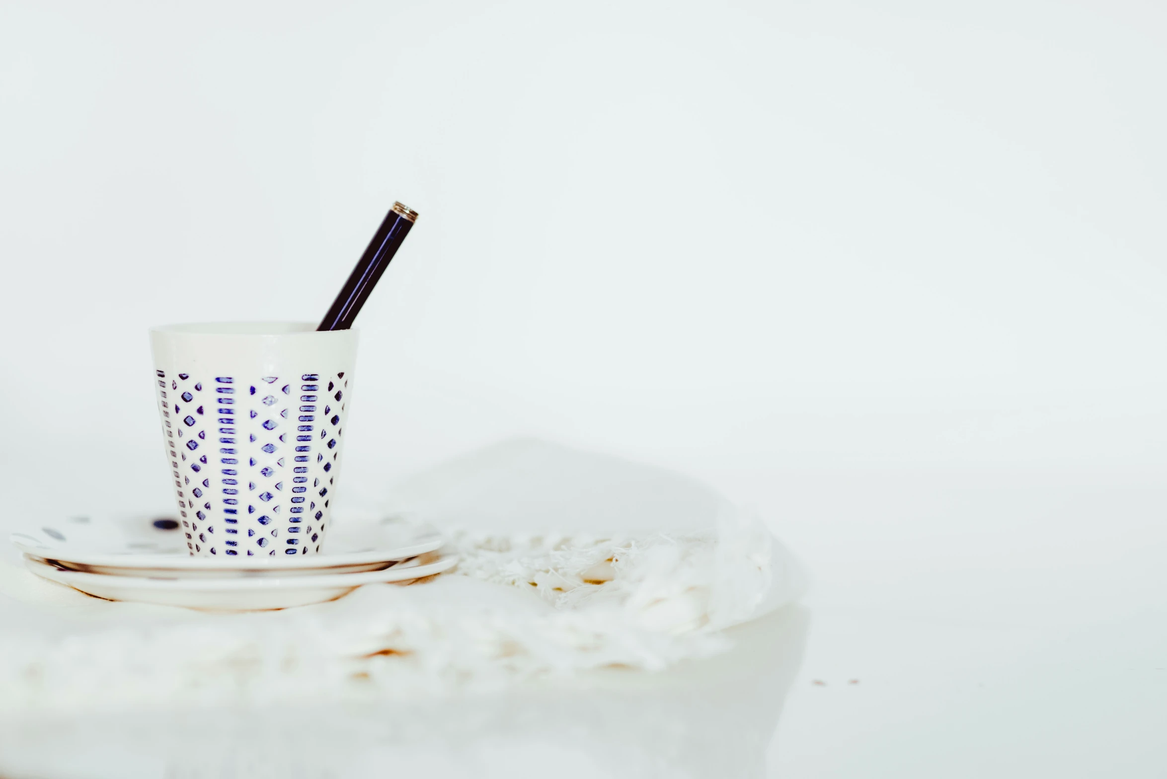 a cup on a plate with some straw inside