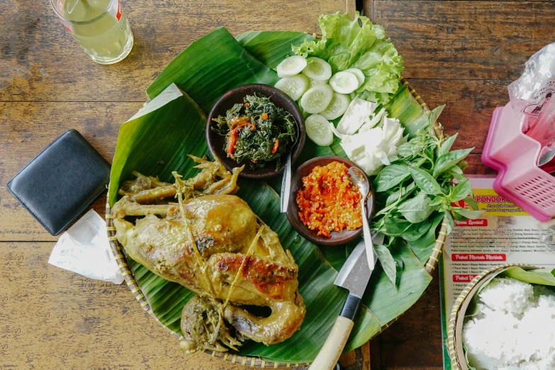 some food on a banana leaf with white sauce