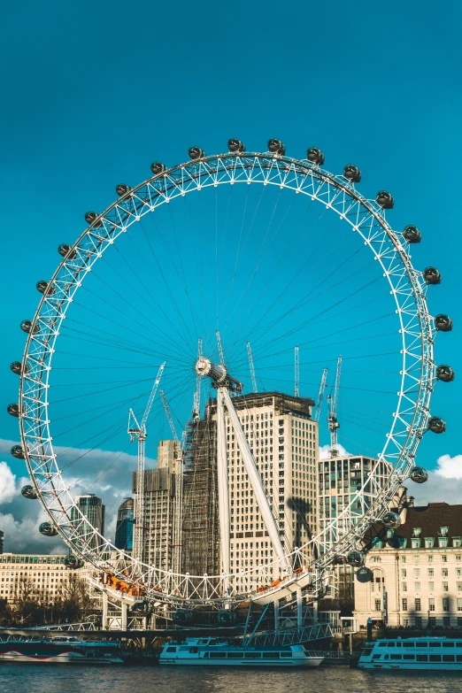 the giant ferris wheel stands tall above a large body of water