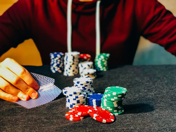 a person sitting at a table with cards and chips