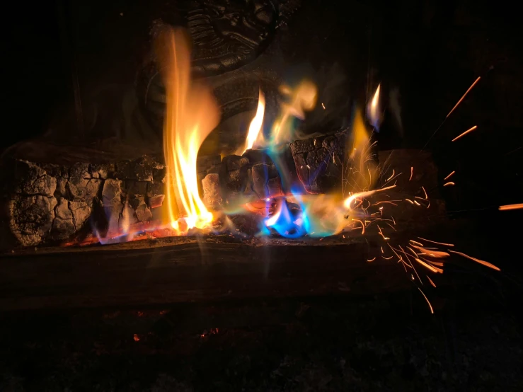 a bunch of colorful fire is shown with flames going in