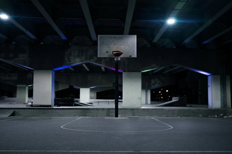 a basketball hoop with lights hanging in the background
