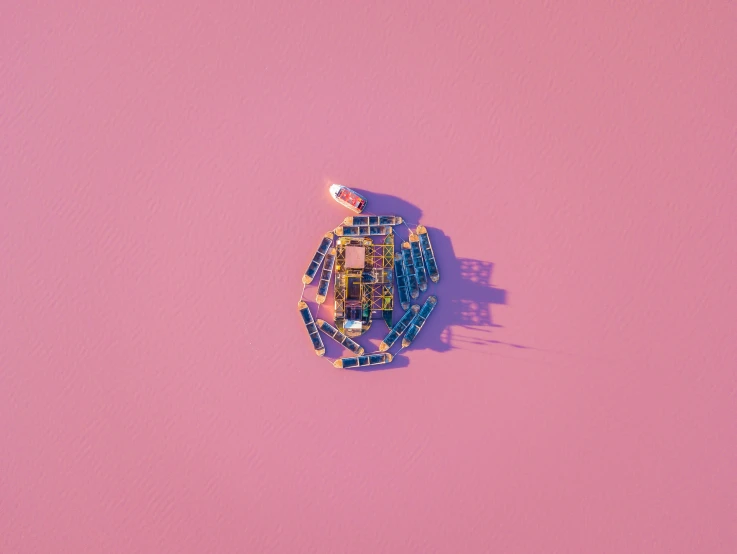 an aerial po of a toy boat on a pink surface