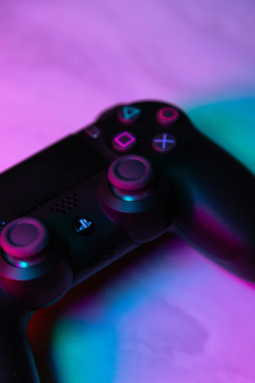 the black wii game controller is glowing on a colored surface