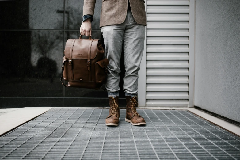 a man with his hand in his pocket standing outside of a building