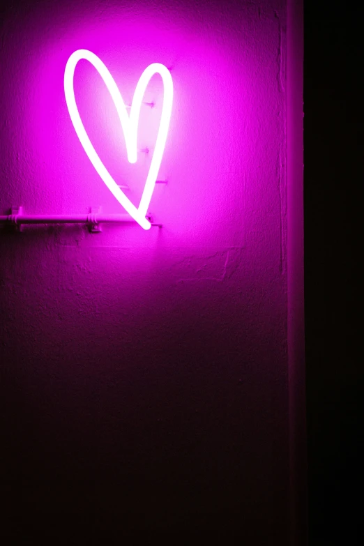 a pink neon sign with the shape of a heart