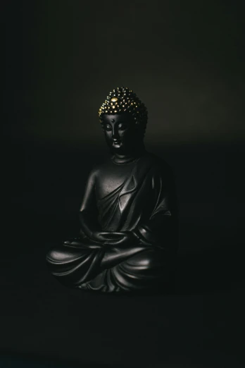 a buddha statue in black and white is sitting alone