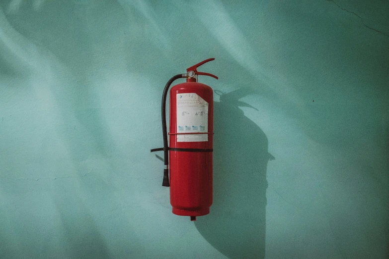 a red fire extinguisher sitting in the middle of a room